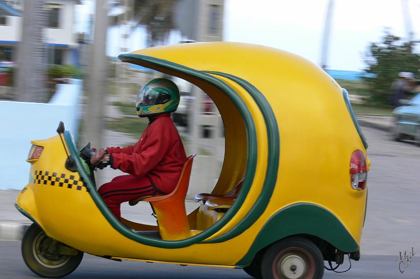 P1110570.JPG - Un cocotaxi. Petit scooter dans une coque jaune servant de taxi pour les courtes distances.