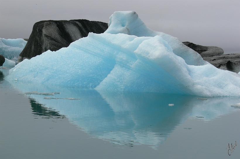 060805_Islande_Jokulsarlon_SE_808.JPG - Les icebergs ont des reflets bleus ou verts selon la compression de la glace ou sont striés de cendres noires, du fait des éruptions fréquentes en Islande. Quand un iceberg apparaît dans un bleu ciel limpide, cela signifie qu’il vient juste de se retourner.