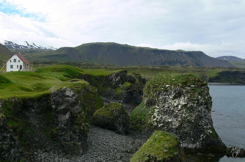 P1010069.JPG - À cette latitude on peut être en bord de mer et voir des sommets enneigés. À l'arrière plan à gauche, le sommet enneigé du volcan Snaefellsjökull ( 1446 m d'altitude, dernière éruption il y a 2000 ans). Au premier plan, une maison de pêcheurs.